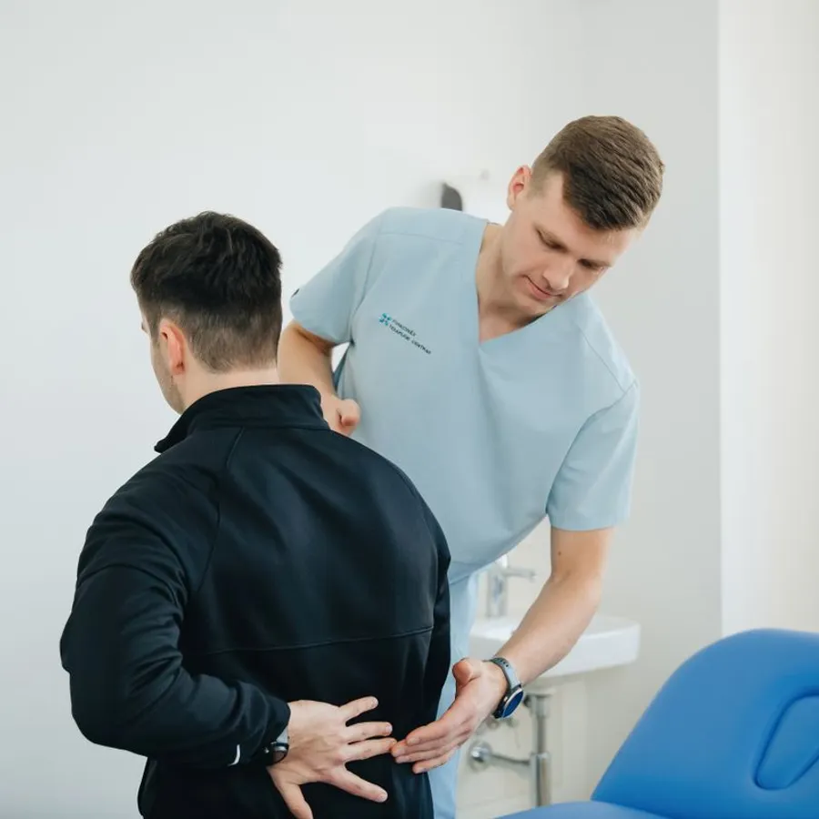 Osteopata valuta il tratto lombare di un paziente con mal di schiena
